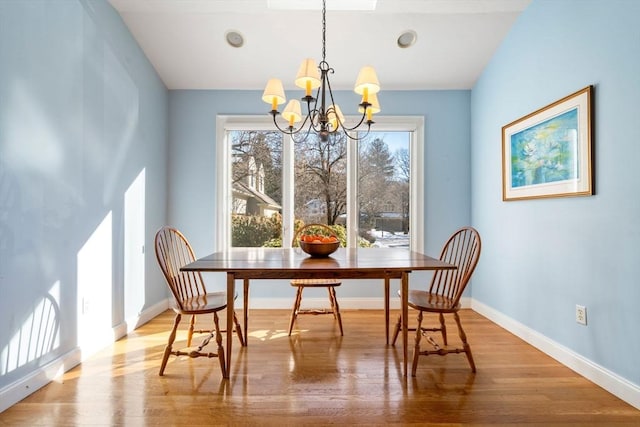 dining space featuring an inviting chandelier and light hardwood / wood-style floors