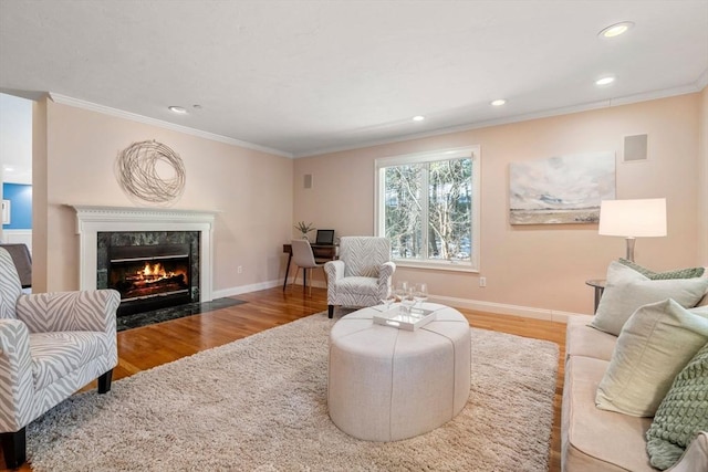 living room featuring hardwood / wood-style flooring, crown molding, and a premium fireplace