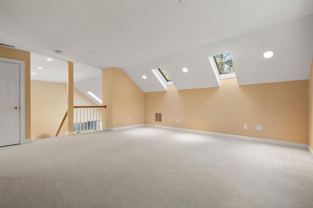 additional living space with lofted ceiling with skylight and light colored carpet