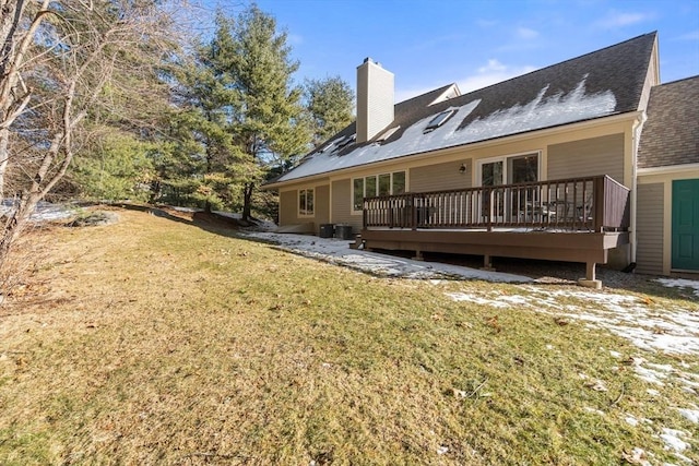 back of property with a wooden deck and a lawn