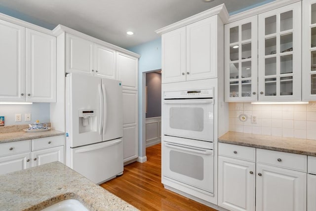 kitchen featuring white appliances, white cabinets, and light wood-type flooring