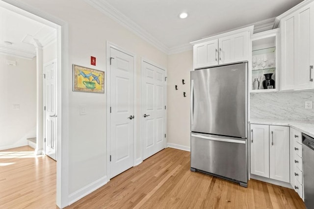 kitchen featuring white cabinetry, stainless steel appliances, and crown molding