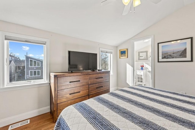 bedroom with baseboards, visible vents, lofted ceiling, ceiling fan, and wood finished floors