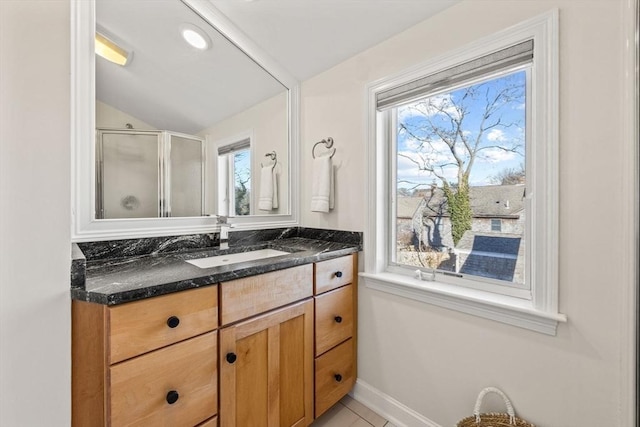 full bathroom with a shower stall, baseboards, vaulted ceiling, and vanity