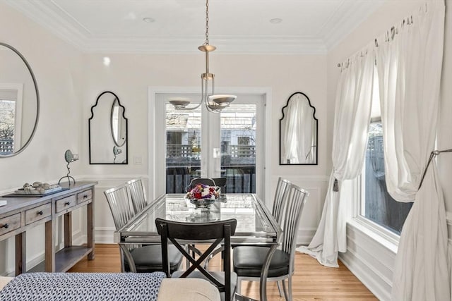 dining space with light wood-style flooring and crown molding