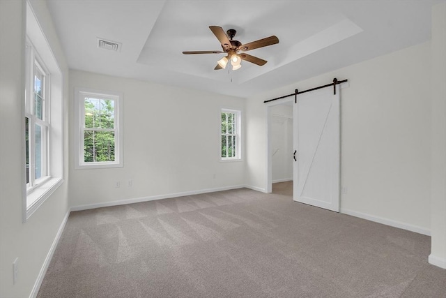 L-244 Doyle Ave, Winchendon, MA 01475 - unfurnished bedroom with a tray ceiling, multiple windows, carpet, and a barn door