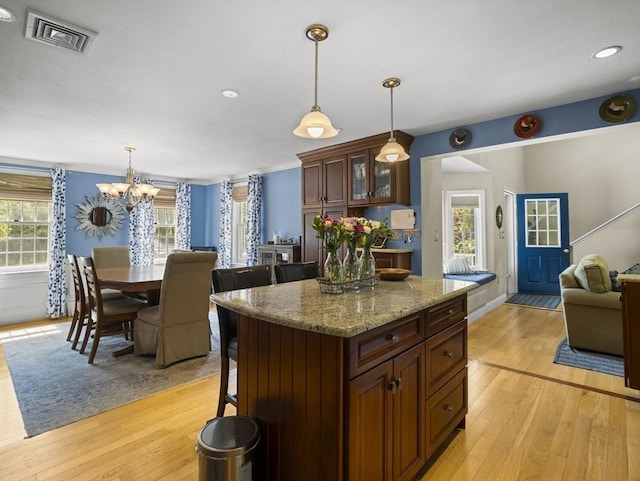 10 Robinhood Rd, Tyngsborough, MA 01879 - kitchen with light wood-style floors, a chandelier, decorative light fixtures, glass insert cabinets, and recessed lighting