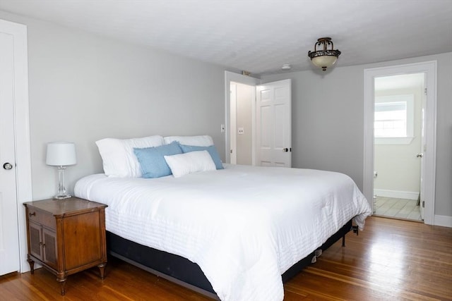 bedroom with baseboards and wood finished floors