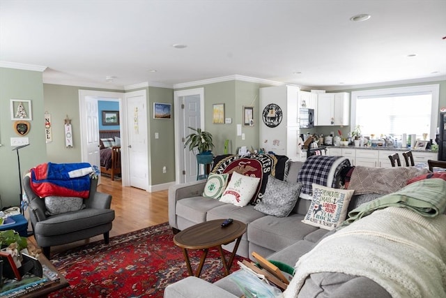 living room with light wood-style flooring, recessed lighting, and ornamental molding