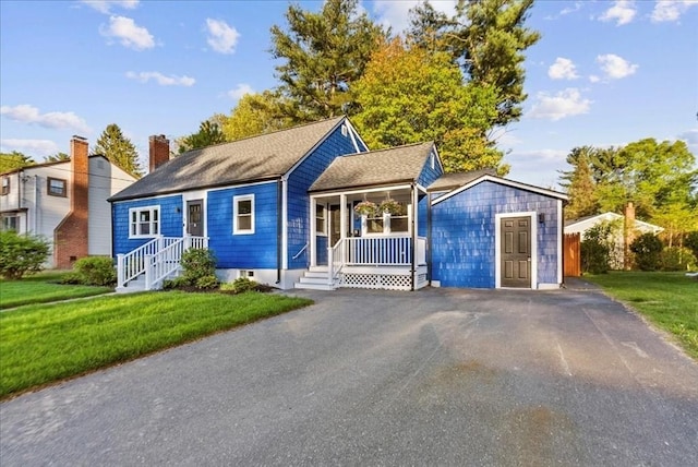 7 Curran Ter, Randolph, MA 02368 - view of front of home featuring a porch, a front lawn, a chimney, and driveway