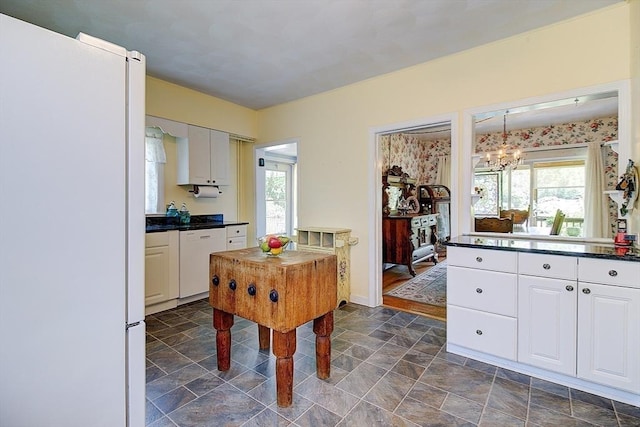 96 Robinson Ave, Attleboro, MA 02703 - kitchen with white appliances, dark countertops, a chandelier, and plenty of natural light