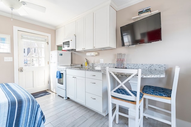 kitchen featuring white appliances, white cabinetry, light hardwood / wood-style flooring, light stone countertops, and ceiling fan