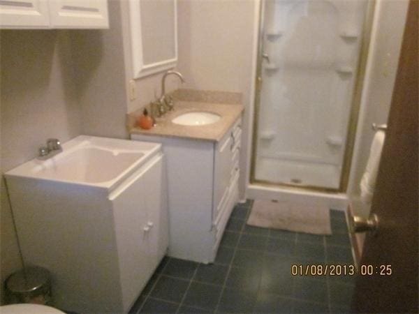 bathroom featuring vanity, tile patterned flooring, and a shower with shower door