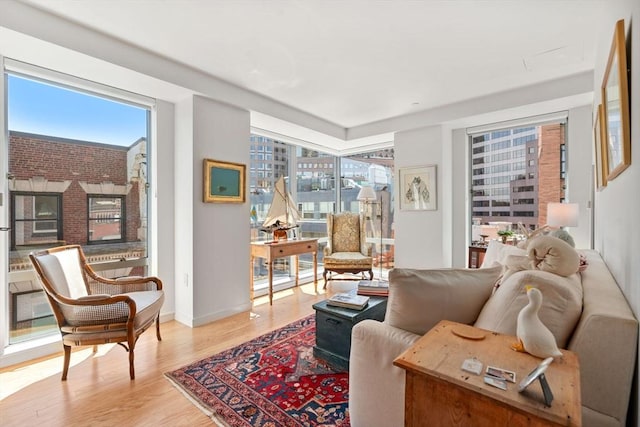 80 Broad St Unit 1002, Boston, MA 02110 - sitting room with plenty of natural light, baseboards, and light wood-type flooring