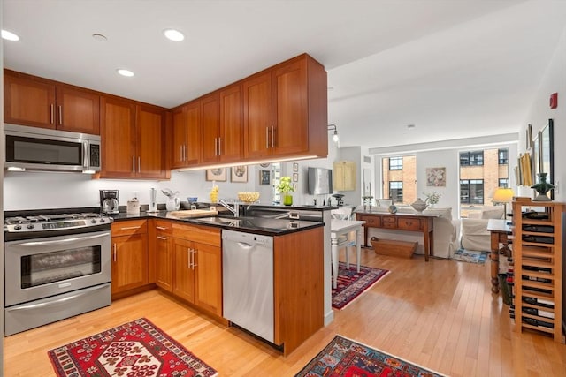 80 Broad St Unit 1002, Boston, MA 02110 - kitchen featuring a sink, light wood-style flooring, open floor plan, and appliances with stainless steel finishes