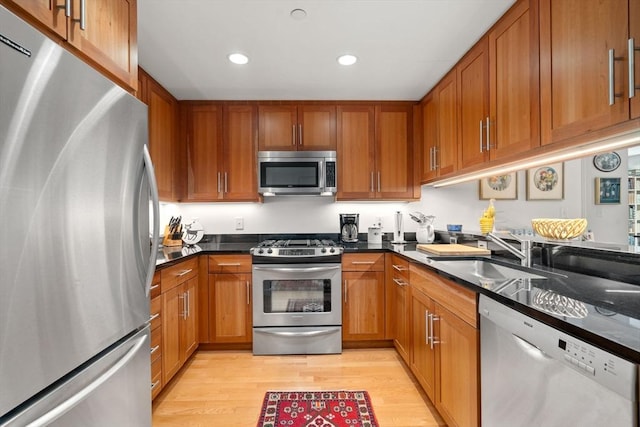 80 Broad St Unit 1002, Boston, MA 02110 - kitchen featuring light wood finished floors, a sink, stainless steel appliances, brown cabinetry, and recessed lighting