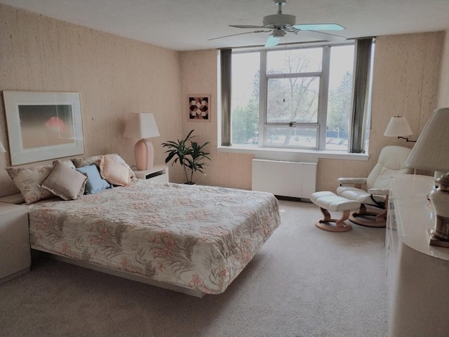carpeted bedroom featuring wallpapered walls and radiator
