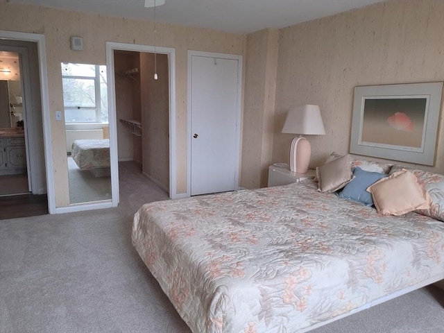 bedroom featuring connected bathroom and carpet