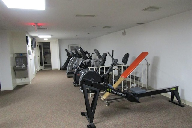 exercise room with carpet floors and baseboards