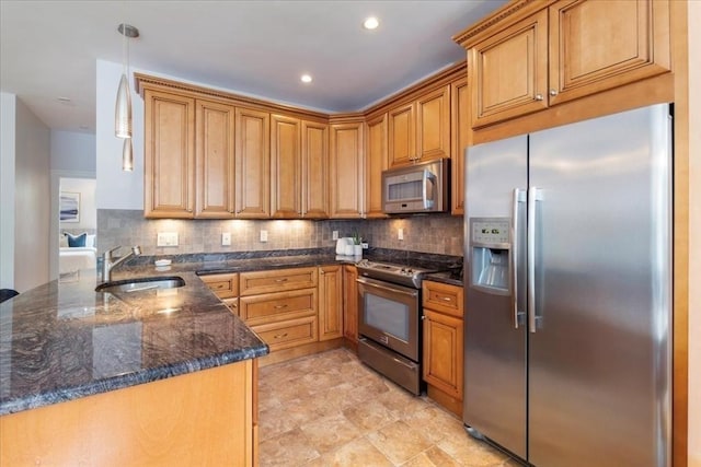 kitchen featuring a sink, decorative backsplash, dark stone countertops, and stainless steel appliances