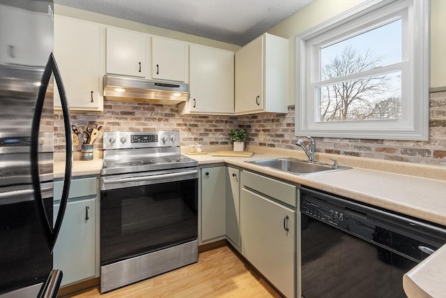 kitchen with refrigerator, stainless steel electric stove, a sink, dishwasher, and under cabinet range hood