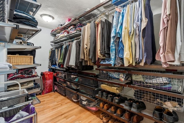 walk in closet with wood finished floors