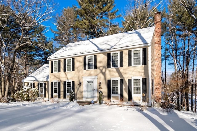 colonial-style house featuring a chimney