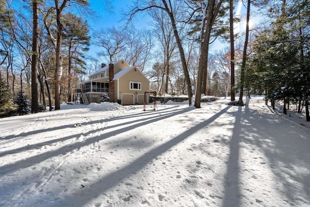 yard covered in snow featuring a sunroom