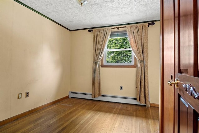 12 Cassidy Dr, Woburn, MA 01801 - empty room with hardwood / wood-style flooring, a baseboard heating unit, crown molding, an ornate ceiling, and baseboards