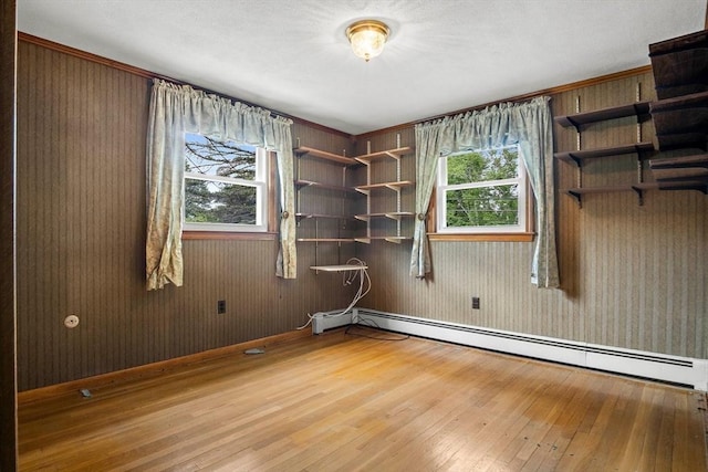 12 Cassidy Dr, Woburn, MA 01801 - unfurnished room with hardwood / wood-style flooring, baseboards, baseboard heating, and wooden walls