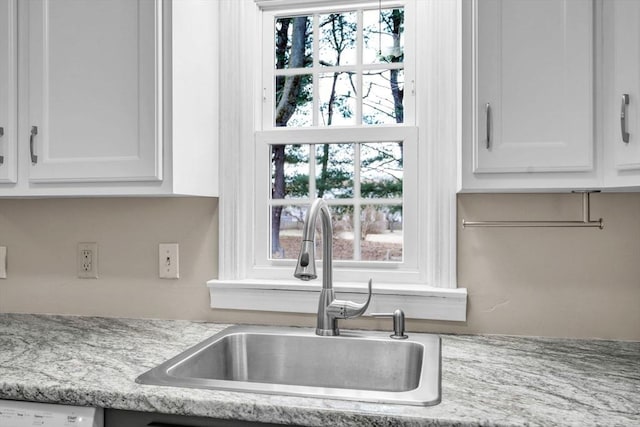 kitchen featuring white cabinetry, sink, dishwasher, and light stone counters