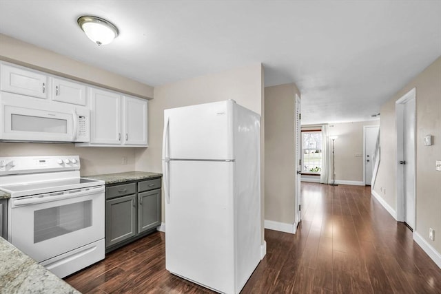 kitchen featuring gray cabinetry, light stone countertops, dark hardwood / wood-style floors, and white appliances