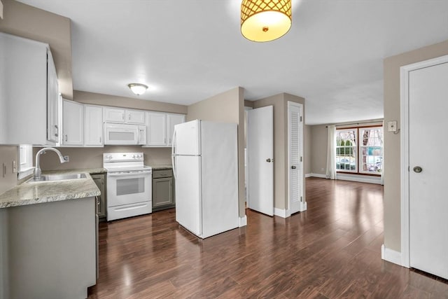 kitchen with light stone countertops, sink, dark wood-type flooring, white appliances, and white cabinets