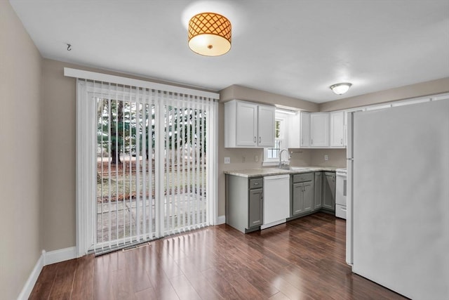 kitchen with white cabinetry, sink, dark wood-type flooring, and white appliances