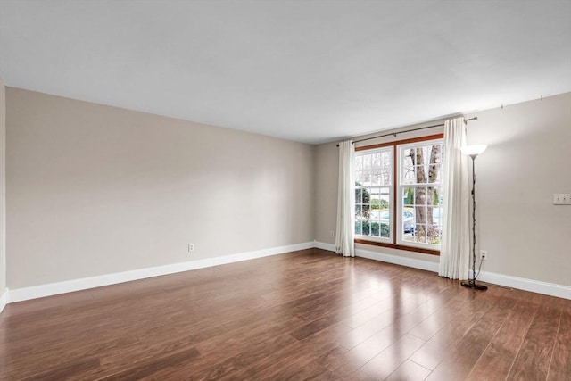 unfurnished room with dark hardwood / wood-style flooring