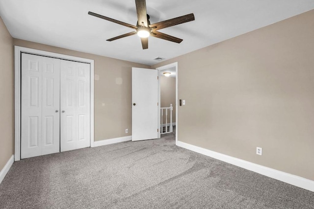 unfurnished bedroom featuring carpet flooring, ceiling fan, and a closet