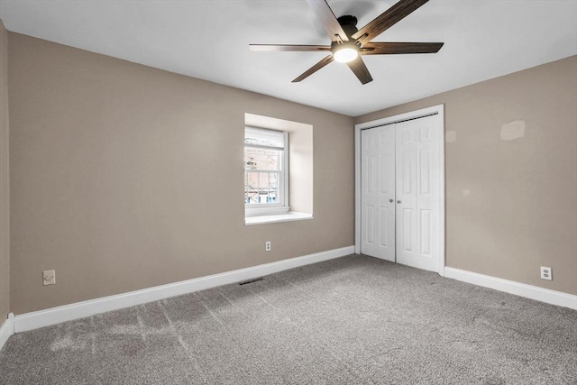 unfurnished bedroom featuring carpet, ceiling fan, and a closet