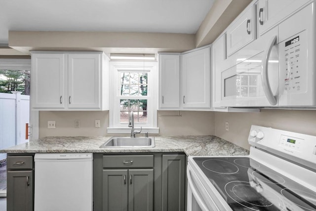 kitchen with gray cabinetry, sink, light stone counters, white appliances, and white cabinets