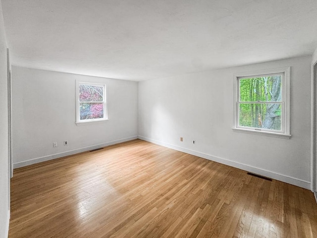 spare room featuring light wood-style floors and baseboards