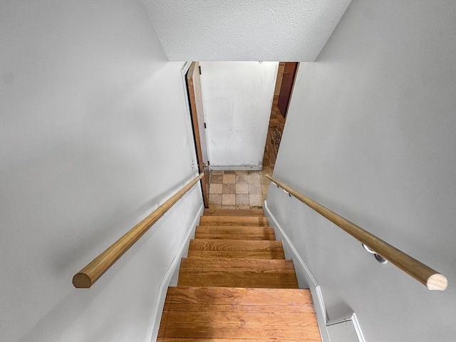 stairs with a textured ceiling