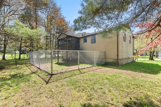 rear view of house with a sunroom and a yard