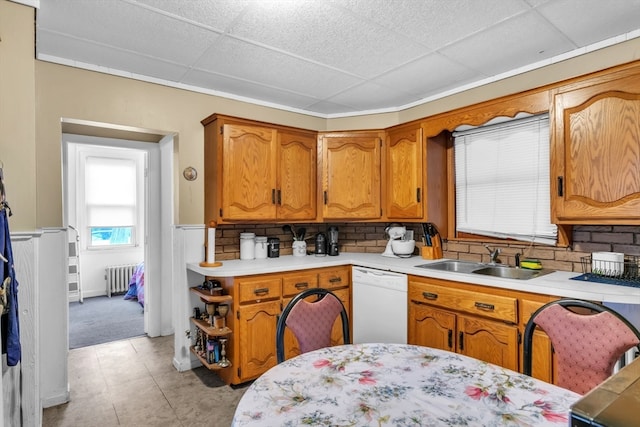 kitchen featuring tasteful backsplash, sink, a drop ceiling, white dishwasher, and radiator heating unit