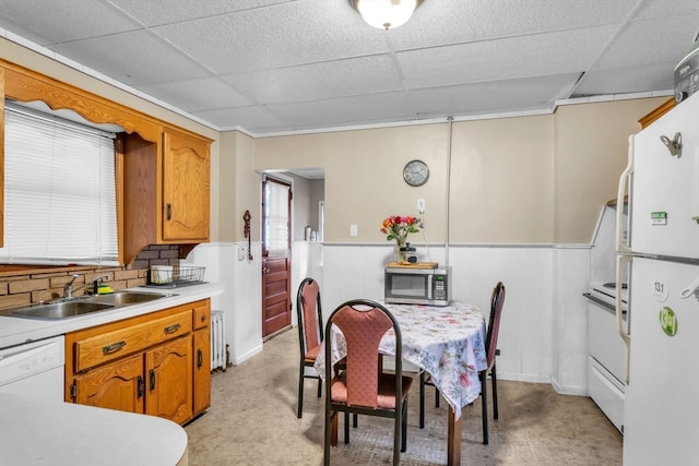 kitchen with a drop ceiling, decorative backsplash, sink, and white appliances