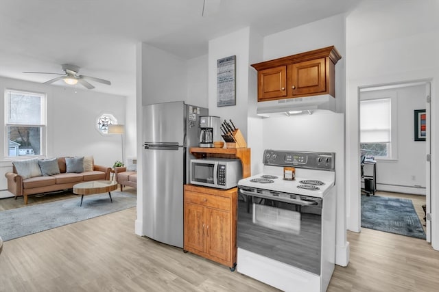 kitchen with light hardwood / wood-style flooring, a baseboard heating unit, stainless steel appliances, and a wealth of natural light