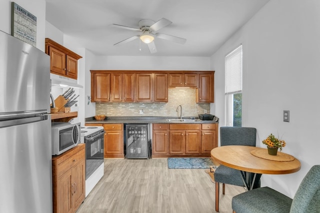 kitchen featuring light hardwood / wood-style flooring, backsplash, wine cooler, sink, and appliances with stainless steel finishes