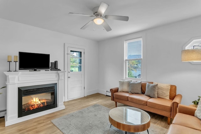 living room featuring light hardwood / wood-style flooring, ceiling fan, and a wealth of natural light