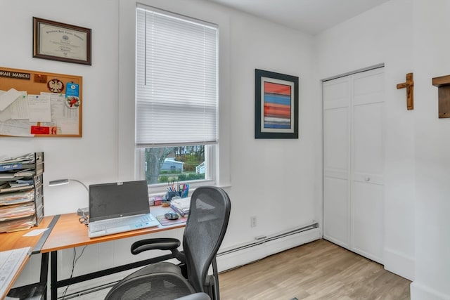 office with a baseboard heating unit and light hardwood / wood-style flooring