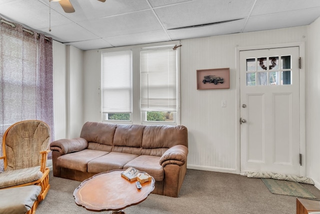 living room featuring a drop ceiling, carpet floors, and ceiling fan