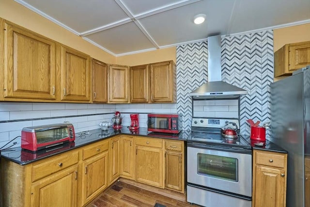 kitchen featuring backsplash, dark countertops, wall chimney exhaust hood, and stainless steel appliances