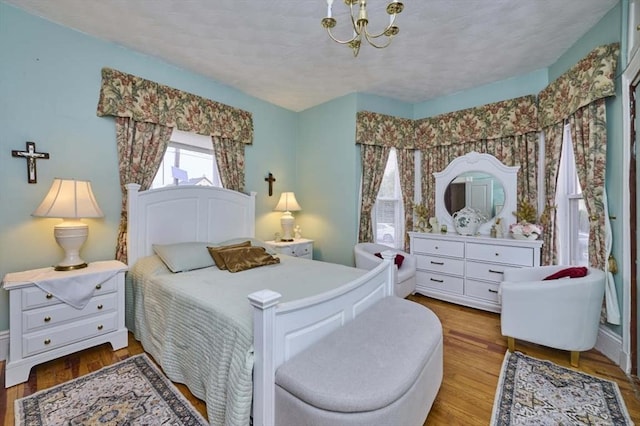 bedroom with wood finished floors and a chandelier